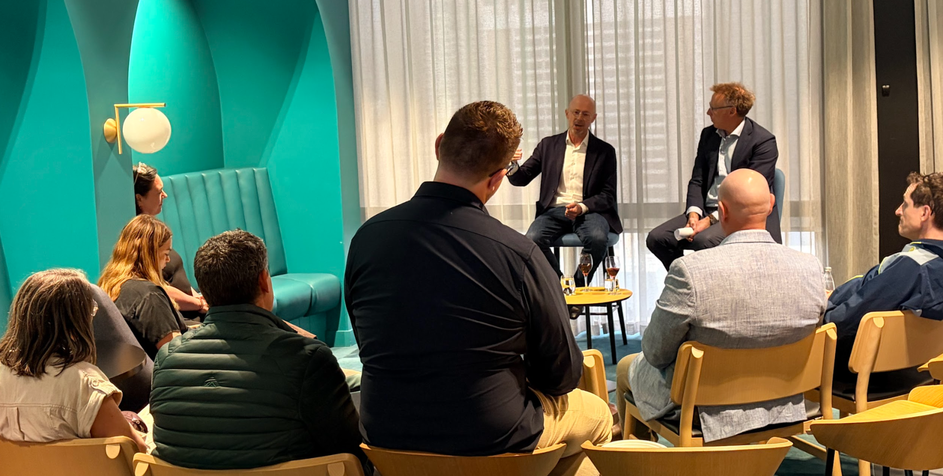 Business meeting with seated attendees and speakers.