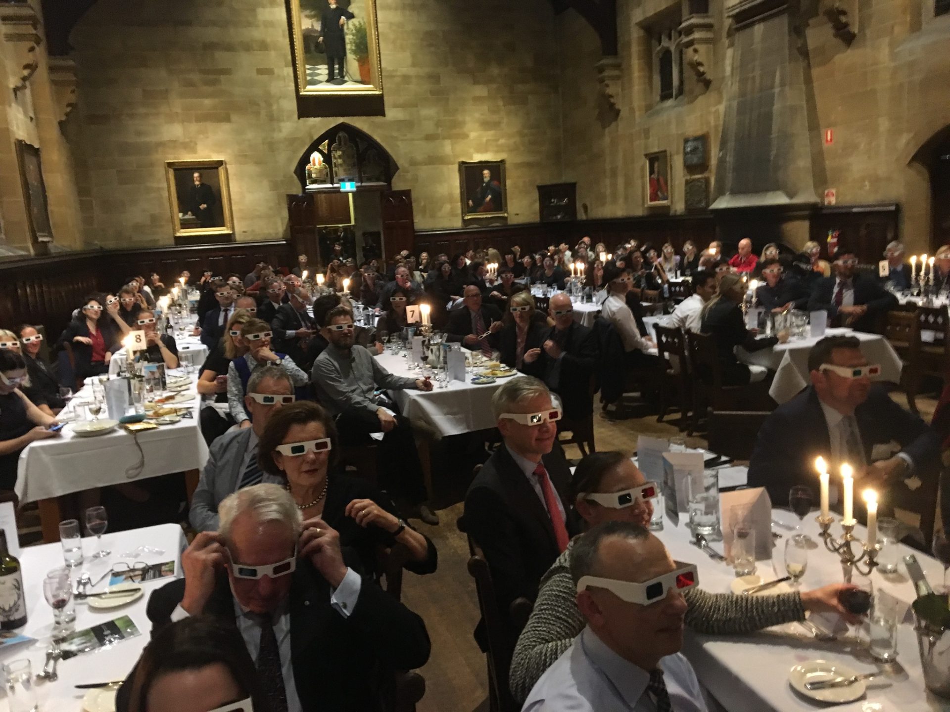 People wearing 3D glasses at a formal dinner.